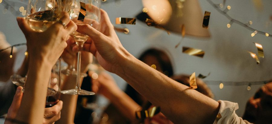 pexels-photo-3171837-3171837 A lively indoor party scene with people toasting champagne glasses amid confetti and warm lights.